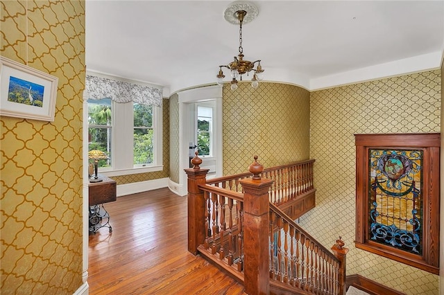 1000 Union St, Brunswick, GA 31520 - corridor with wallpapered walls, an upstairs landing, wood finished floors, and a chandelier