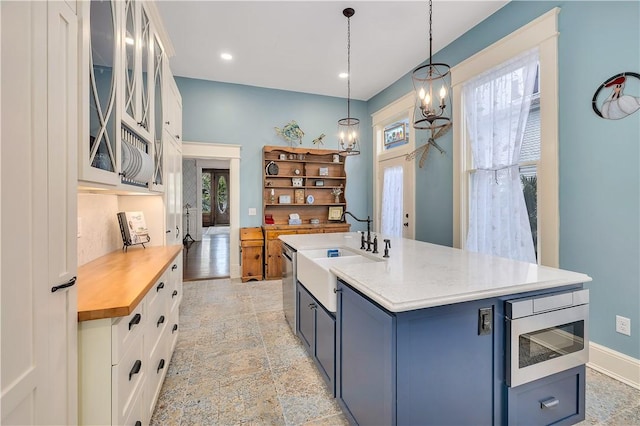 1000 Union St, Brunswick, GA 31520 - kitchen featuring white cabinets, stainless steel appliances, decorative light fixtures, a chandelier, and glass insert cabinets