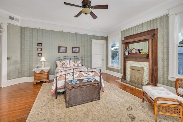 1000 Union St, Brunswick, GA 31520 - bedroom with crown molding, wallpapered walls, wood finished floors, a fireplace, and a ceiling fan