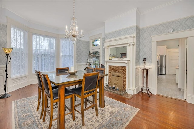 1000 Union St, Brunswick, GA 31520 - dining space featuring wallpapered walls, a chandelier, a wainscoted wall, ornamental molding, and a decorative wall