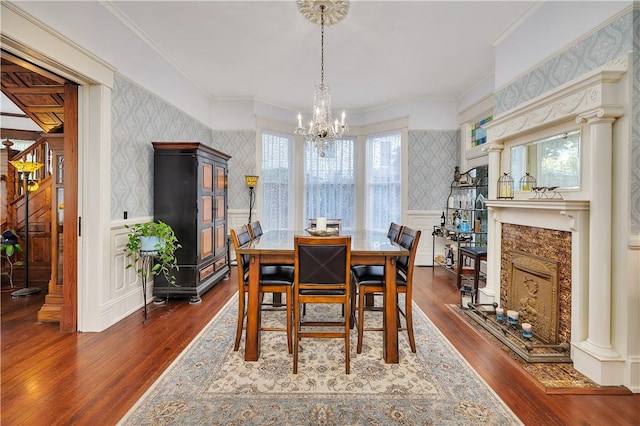 1000 Union St, Brunswick, GA 31520 - dining space featuring wallpapered walls, a chandelier, dark wood-type flooring, wainscoting, and a decorative wall