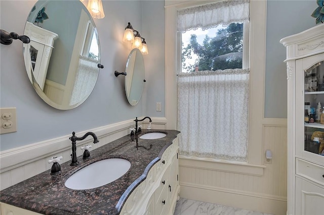 1000 Union St, Brunswick, GA 31520 - full bath featuring marble look tile flooring, a wainscoted wall, double vanity, and a decorative wall