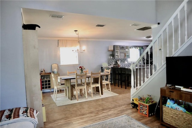 102 Avalon Ct, Kingsland, GA 31548 - dining space with stairs, wood finished floors, and crown molding