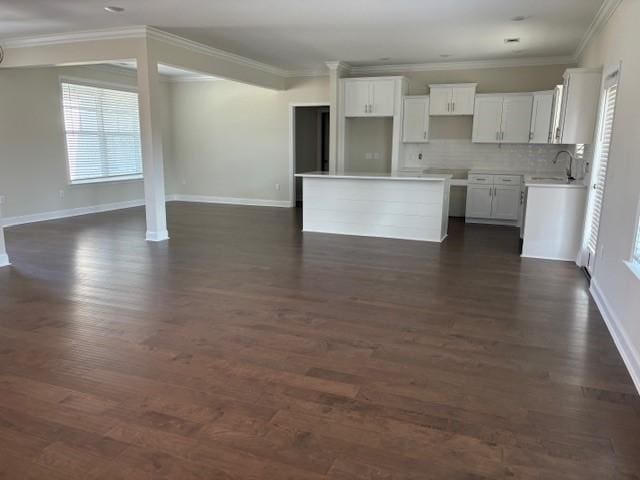 kitchen with a kitchen island, white cabinetry, dark wood-type flooring, and backsplash