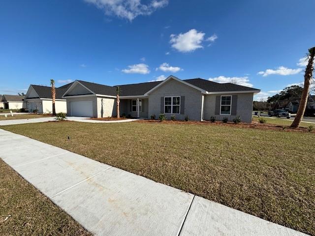 ranch-style house featuring an attached garage, stucco siding, driveway, and a front yard