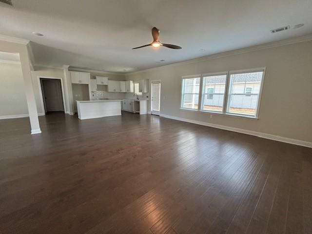 unfurnished living room featuring dark wood-style flooring, crown molding, visible vents, ceiling fan, and baseboards