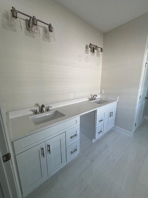 bathroom featuring a sink, baseboards, and double vanity