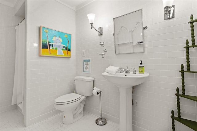 bathroom featuring toilet, a shower with shower curtain, and tile walls