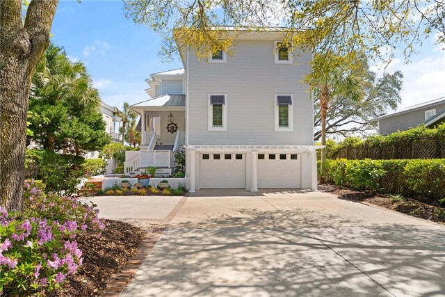 view of front of home with concrete driveway, an attached garage, a standing seam roof, and metal roof
