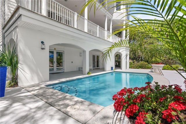 outdoor pool featuring a patio area and french doors