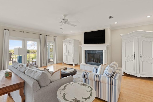 living area featuring light wood finished floors, visible vents, recessed lighting, a ceiling fan, and ornamental molding