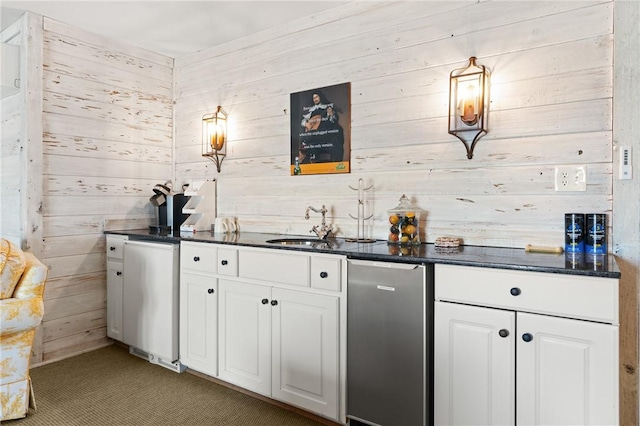 bar with light carpet, wood walls, a sink, and fridge