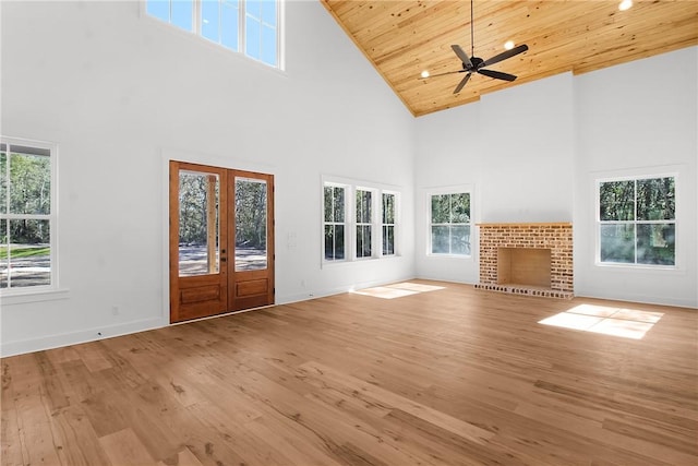 unfurnished living room with wood ceiling, ceiling fan, french doors, high vaulted ceiling, and light hardwood / wood-style flooring