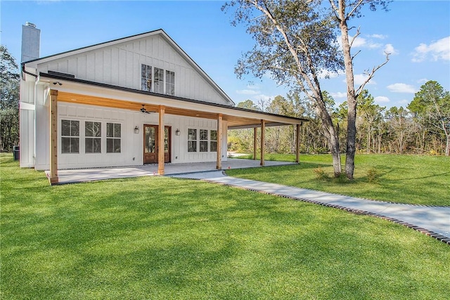 back of property featuring ceiling fan, a patio area, and a lawn