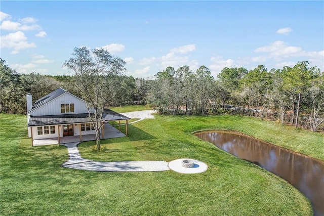 exterior space with a water view, a fire pit, and a patio