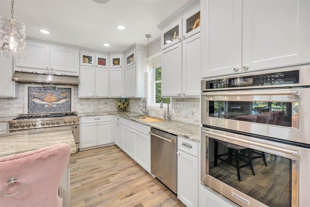 kitchen with light stone countertops, white cabinetry, and stainless steel appliances