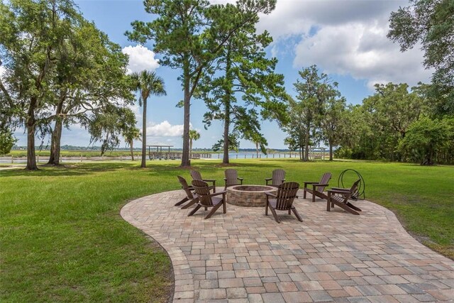 view of patio with a water view and an outdoor fire pit