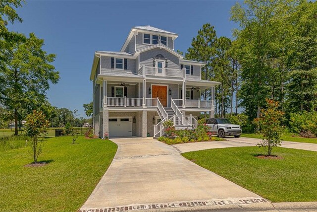 coastal home with a porch, a garage, and a front yard