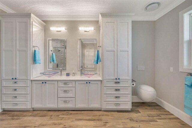 bathroom featuring hardwood / wood-style flooring, vanity, and ornamental molding