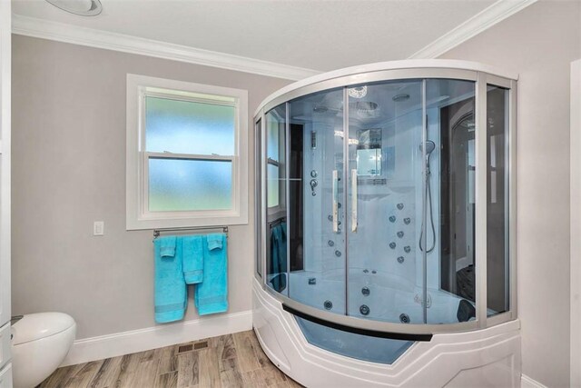 bathroom featuring hardwood / wood-style floors, toilet, ornamental molding, and bath / shower combo with glass door