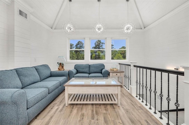 living room featuring light hardwood / wood-style flooring, high vaulted ceiling, a chandelier, and ornamental molding