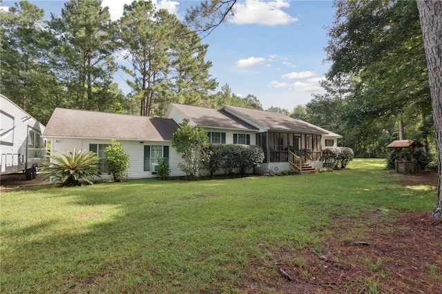 ranch-style home featuring a sunroom and a front lawn