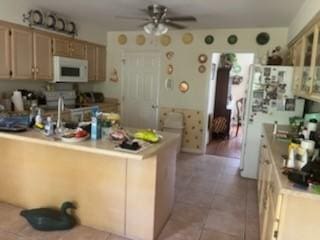 3042 Charing Cross Cross, Brunswick, GA 31525 - kitchen with white microwave, a ceiling fan, a peninsula, electric range, and light countertops