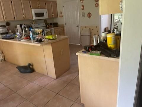 3042 Charing Cross Cross, Brunswick, GA 31525 - kitchen with white microwave, stainless steel electric range oven, a peninsula, light tile patterned flooring, and light countertops