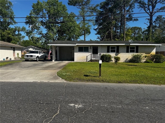 ranch-style house with a carport, stucco siding, driveway, and a front yard