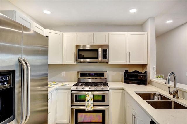 828 Lee St, Brunswick, GA 31520 - kitchen with appliances with stainless steel finishes, white cabinets, recessed lighting, and light stone countertops