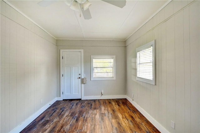 828 Lee St, Brunswick, GA 31520 - empty room with dark wood-style floors, ceiling fan, and wooden walls