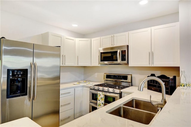 828 Lee St, Brunswick, GA 31520 - kitchen featuring appliances with stainless steel finishes, light stone countertops, white cabinets, and recessed lighting