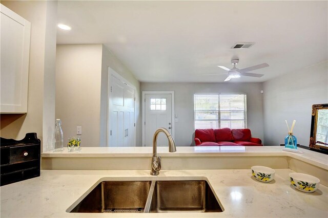 828 Lee St, Brunswick, GA 31520 - kitchen with open floor plan, white cabinets, a ceiling fan, and light stone countertops