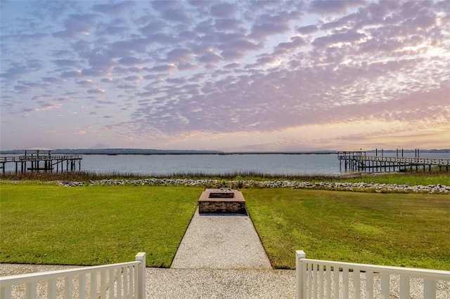 dock area with a water view and a yard