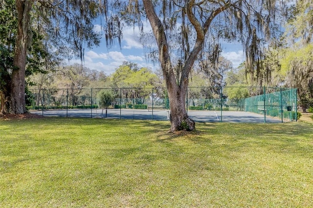 view of tennis court with a yard