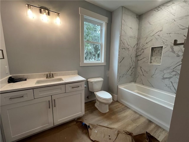 full bathroom featuring vanity, tiled shower / bath, hardwood / wood-style floors, and toilet