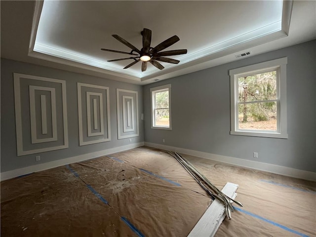 unfurnished room featuring ceiling fan and a tray ceiling