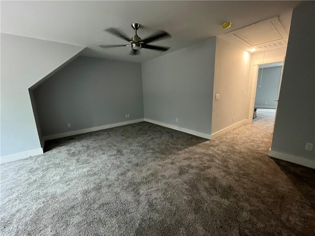 bonus room featuring ceiling fan and dark carpet