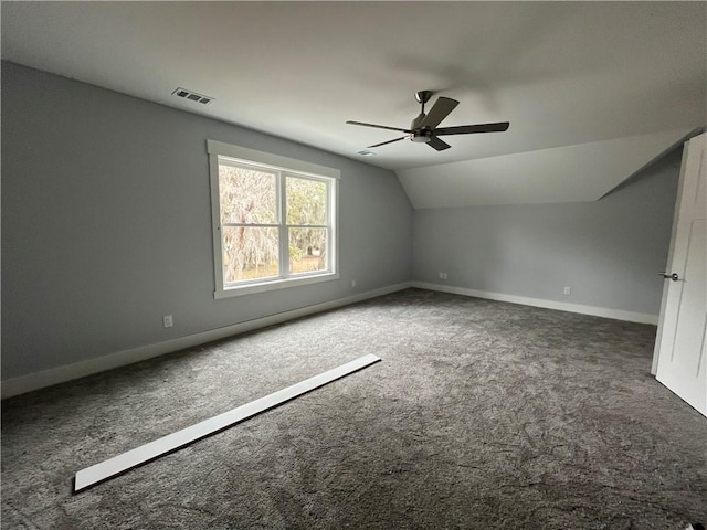 additional living space with vaulted ceiling, ceiling fan, and dark colored carpet