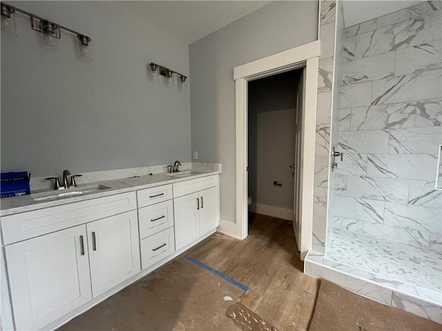 bathroom with vanity, wood-type flooring, and tiled shower