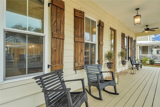 wooden terrace with ceiling fan and covered porch