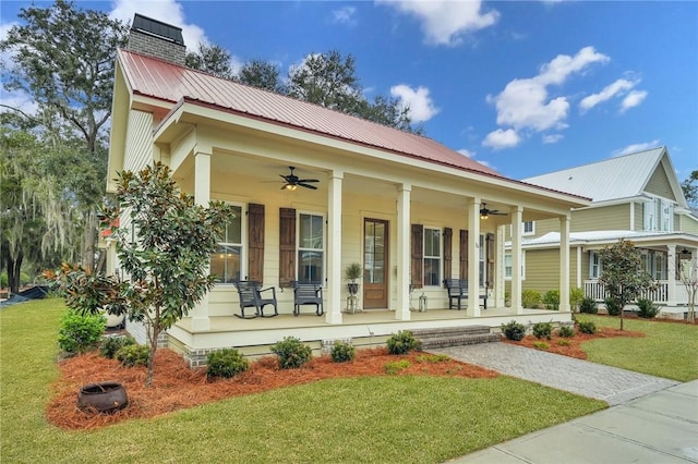 view of front of house with ceiling fan, a front yard, and covered porch