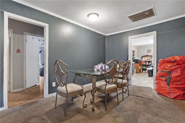 dining room with ornamental molding, carpet floors, and a textured ceiling