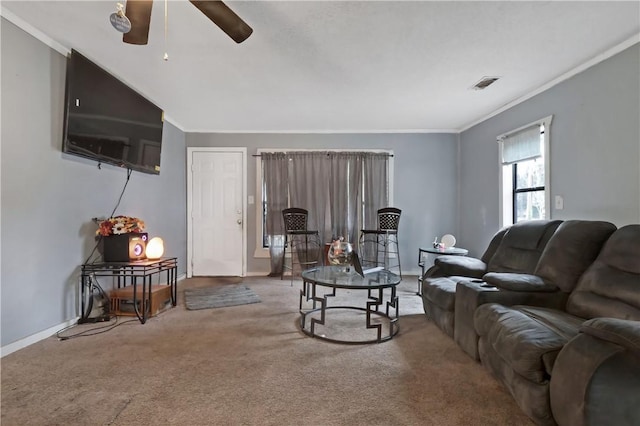 living room with ornamental molding, ceiling fan, and carpet flooring