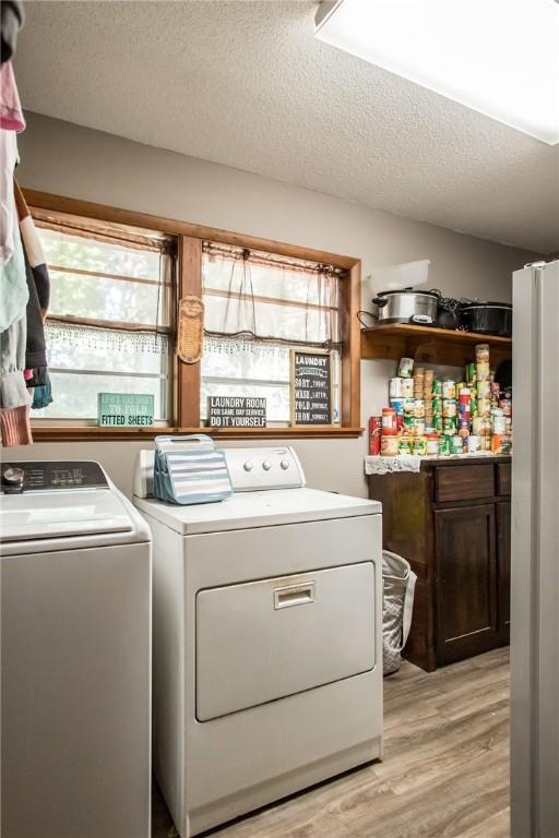 1405 Grove Ave, Waycross, GA 31501 - laundry area with independent washer and dryer, light wood finished floors, plenty of natural light, a textured ceiling, and cabinet space