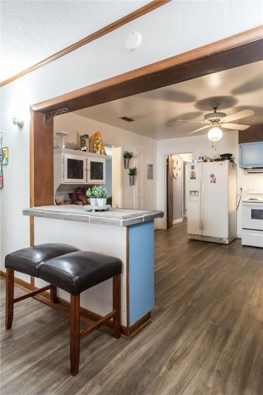 1405 Grove Ave, Waycross, GA 31501 - kitchen with white appliances, dark wood finished floors, ornamental molding, a ceiling fan, and baseboards