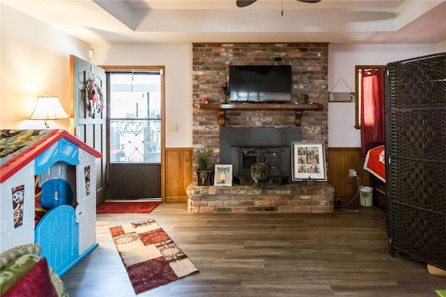 1405 Grove Ave, Waycross, GA 31501 - living area with a wainscoted wall, wood finished floors, ceiling fan, wood walls, and a raised ceiling