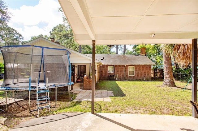 1405 Grove Ave, Waycross, GA 31501 - view of green lawn featuring a trampoline and a patio