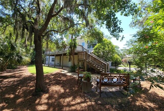 412 Palm Dr, Saint Simons Island, GA 31522 - rear view of house featuring a wooden deck, a chimney, a patio area, a yard, and stairway