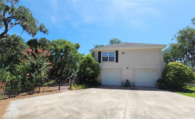 412 Palm Dr, Saint Simons Island, GA 31522 - view of side of home featuring stucco siding, driveway, and an attached garage
